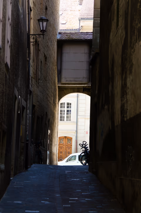 narrow alley with old buildings and archway