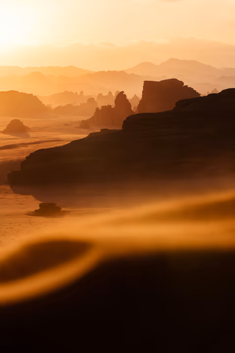 the sun setting over a desert landscape