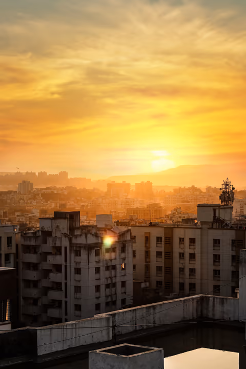 the sun setting over a city with tall buildings