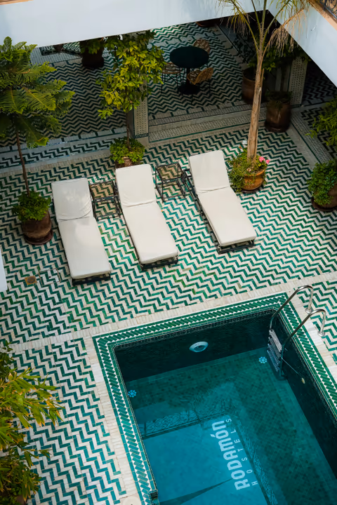 three sun loungers beside the courtyard pool
