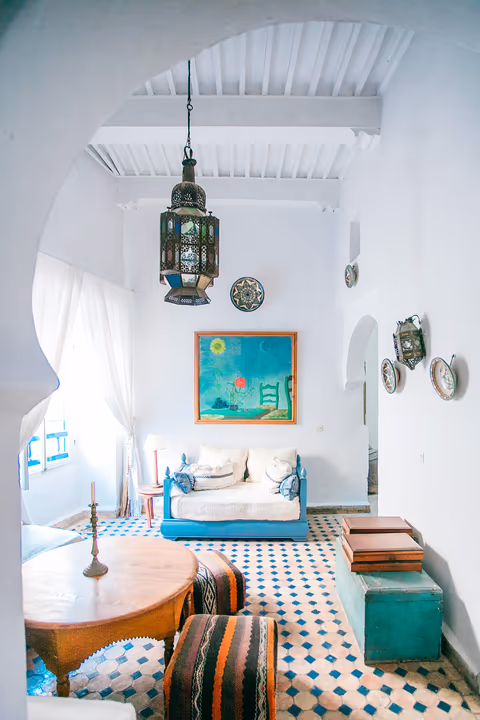 white sitting room with a daybed and lanterns