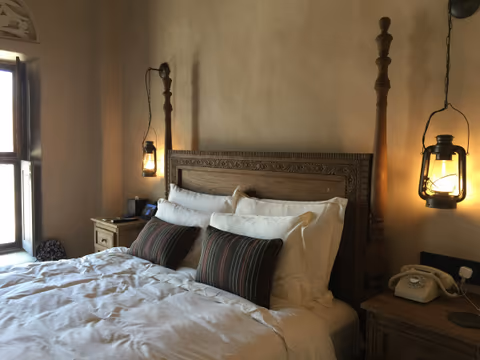 bed with a carved wooden headboard and lanterns