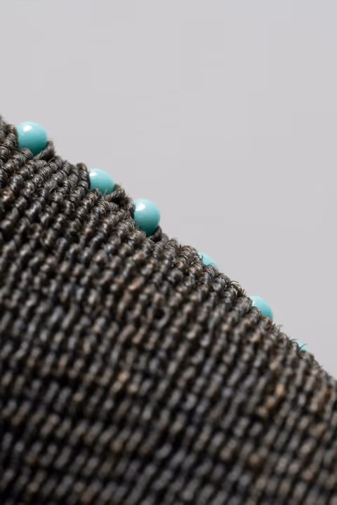 dark woven fabric with turquoise beads