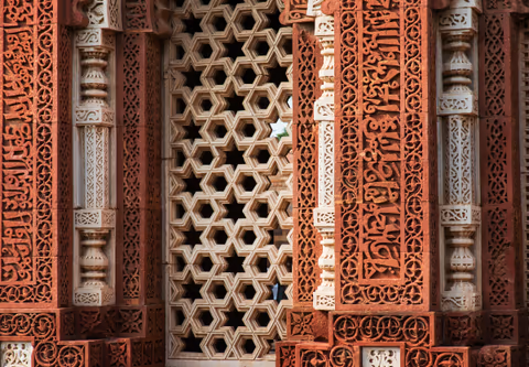 intricate carvings on red sandstone architecture