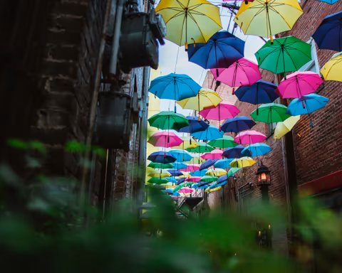 colorful umbrellas hanging over a narrow alley