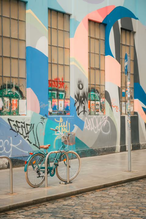 a bicycle by a colorful graffiti wall