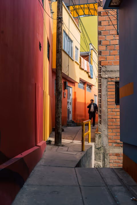 a man walking next to tall buildings